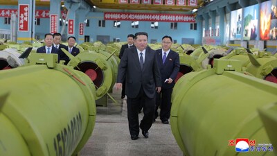 This undated picture released by North Korea's official Korean Central News Agency (KCNA) on December 26, 2025 shows North Korean leader Kim Jong Un (C) visiting major munitions industry enterprises to acquaint himself with the missile and shell production at an undisclosed place in North Korea. (Photo by KCNA VIA KNS / AFP)