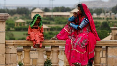 (FILES) A Pakistani Hindu devotee woman and a girl sit while waiting with others for transport before leaving to pay homage at Hinglaj Mata Temple in Balochistan, outside the Shri Ratneshwar Mahadev Temple in Karachi, Pakistan April 28, 2023. REUTERS/Akhtar Soomro
