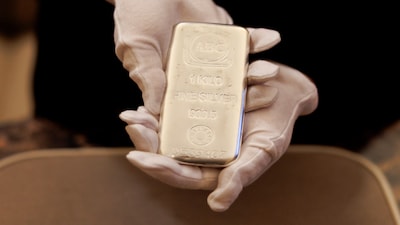 An employee holds a one kilogram silver bar at an ABC Bullion store in Sydney, Australia, on Tuesday, Oct. 21, 2025. Gold held near a record high, finding support despite optimism global trade tensions are easing and hopes the US government will reopen soon.