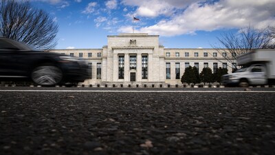 Vehicles pass in front of the Marriner S. Eccles Federal Reserve building in Washington. Photographer: Al Drago/Bloomberg