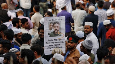 A man holds a placard as tens of thousands of people join the funeral prayer for Sharif Osman Hadi, a student leader, who died after being shot in the head, at the Parliament building area of Manik Mia Avenue, in Dhaka, Bangladesh, December 20, 2025. REUTERS/Mohammad Ponir Hossain