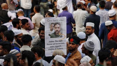 A man holds a placard as tens of thousands of people join the funeral prayer for Sharif Osman Hadi, a student leader, who died after being shot in the head, at the Parliament building area of Manik Mia Avenue, in Dhaka, Bangladesh, December 20, 2025. REUTERS/Mohammad Ponir Hossain
