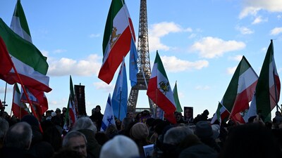 Protesters wave pre-1979 Islamic Revolution flags of Iran as they gather for a demonstration against the Iranian regime's crackdown on protests in central Paris, on January 4, 2026. (Photo by Blanca CRUZ / AFP)