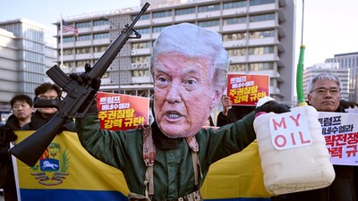 A protester wearing a mask of US President Donald Trump performs during a demonstration condemning the US attack on Venezuela and the seizure of Venezuelan leader Nicolas Maduro, in front of the US embassy in Seoul on January 5, 2026. (Photo by Jung Yeon-je / AFP)