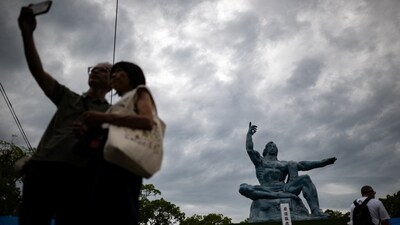 People take pictures in front of the Peace Statue in Nagasaki Peace Park on August 8, 2025 ahead of the 80th anniversary of the atomic bombing of Nagasaki. (Photo by Philip FONG / AFP)