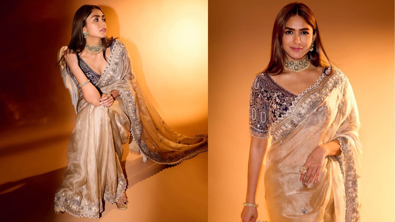 Stunning in organza Mrunal stuns in a luxurious champagne-toned saree featuring an intricately embellished border. The highlight is the deep purple velvet blouse, heavily encrusted with silver zardozi work. Topped with a regal emerald and diamond choker, this ensemble celebrates traditional Indian craftsmanship with a timeless, high-glamour appeal.