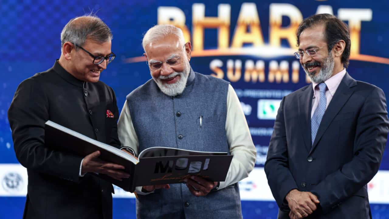 Prime Minister Narendra Modi receives a copy of ‘Modi at 75’ from Rahul Joshi (R), Network18 Group Editor-in-Chief, and Brajesh Kumar Singh, Group Editor for Integration and Convergence.