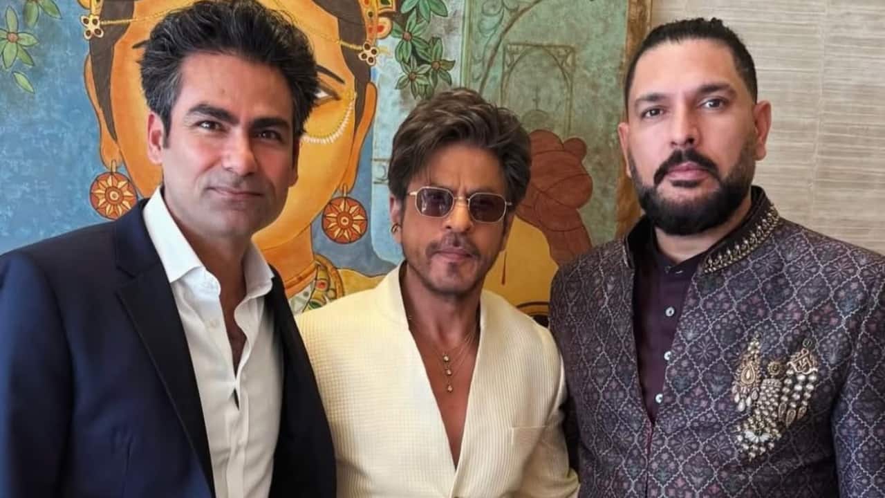 Shah Rukh Khan’s charismatic entry Shah Rukh Khan wore a sherwani with a cream hue and a self-patterned, textured cloth. With a distinctive open-neck style and a vertical row of elaborate, dark-toned buttons that contrast sharply with the light fabric, the fitted piece has a modern touch. He combines traditional royalty with his distinctive modern style by wearing the sherwani with matching trousers and accessorising with stacked gold chains and tinted aviator sunglasses. Shah Rukh Khan’s charismatic entry Shah Rukh Khan wore a sherwani with a cream hue and a self-patterned, textured cloth. With a distinctive open-neck style and a vertical row of elaborate, dark-toned buttons that contrast sharply with the light fabric, the fitted piece has a modern touch. He combines traditional royalty with his distinctive modern style by wearing the sherwani with matching trousers and accessorising with stacked gold chains and tinted aviator sunglasses.