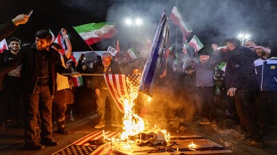 Iranians set fire to US and Israel flags in Tehran on March 17. Source: Bloomberg