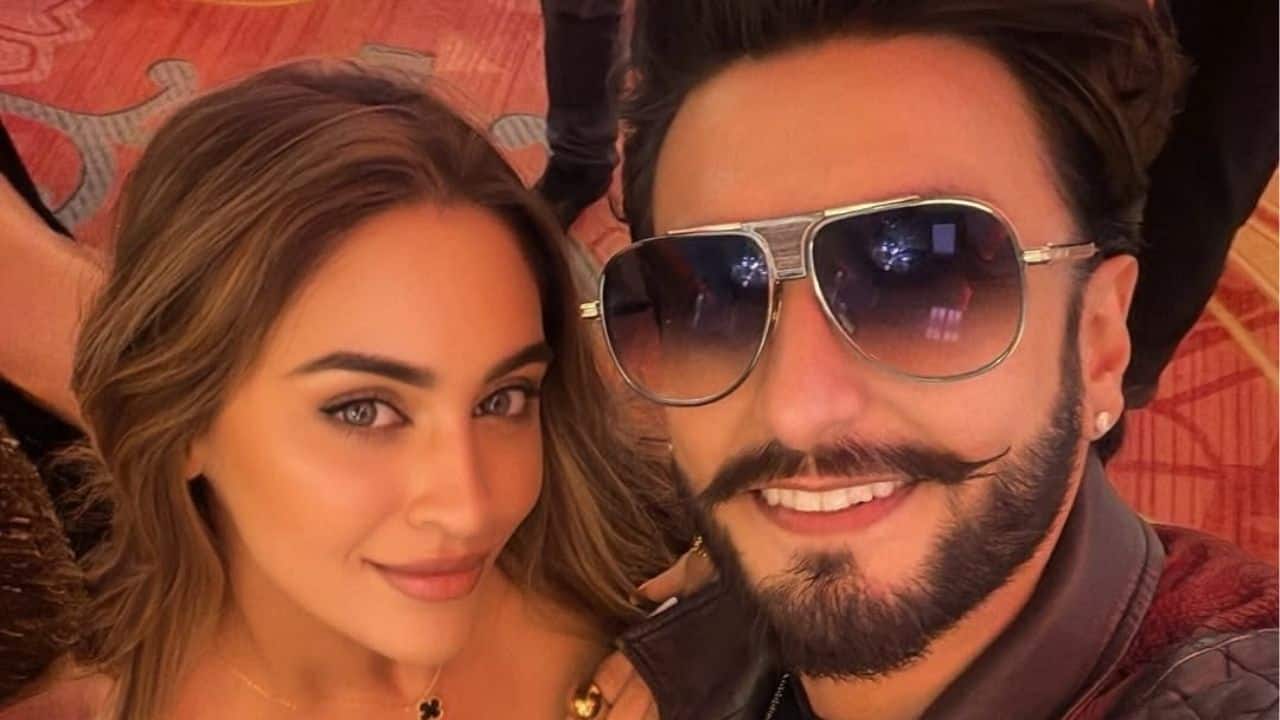 Ranveer Singh and Krystle D'souza share a close-up selfie, both flashing confident smiles. The frame captures a playful, high-energy moment from the night.