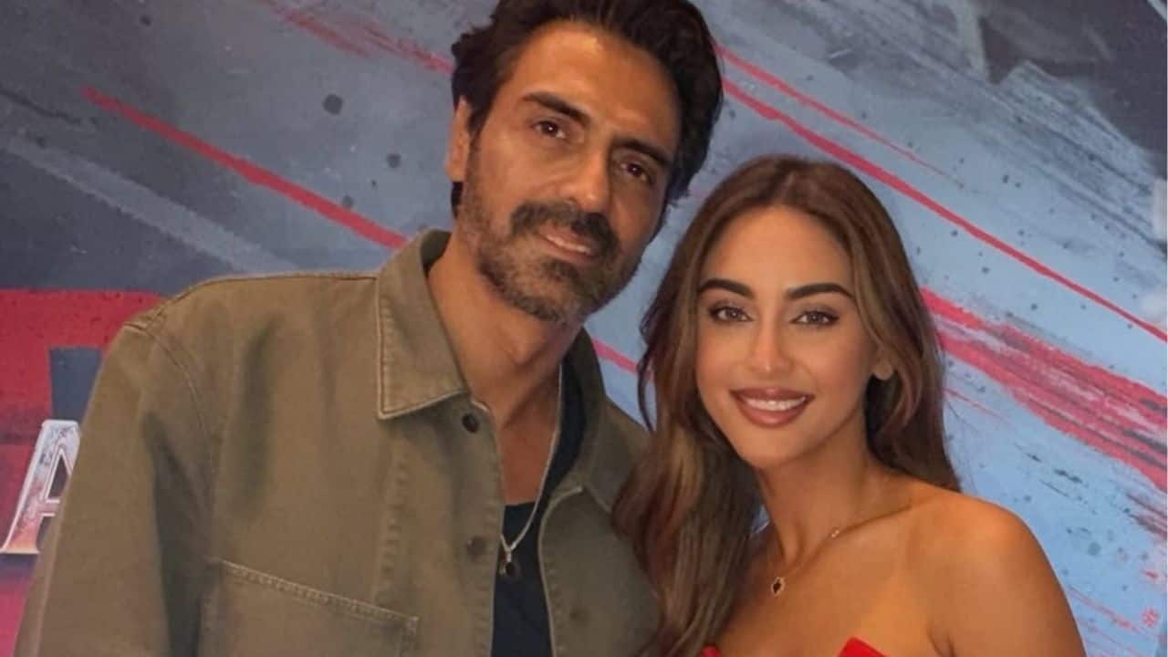 Arjun Rampal is seen posing with Krystle D'souza, both looking relaxed and camera-ready. The candid frame captures a warm, friendly moment between the two.