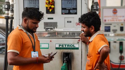 Petrol pump attendants count currency notes after refuelling a vehicle at an Indian Oil fuel station in Varanasi on March 10, 2026. (Photo by Niharika KULKARNI / AFP)