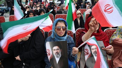 Iranian women hold portraits of Iran's supreme leader Mojtaba Khamenei while gathering in front of Tehran's Mellat park on April 2, 2026, during "Sizdeh Bedar" (Nature Day), the 13th day after the Nowruz Persian New Year, when people traditionally picnic outdoors with family and friends. (AFP)
