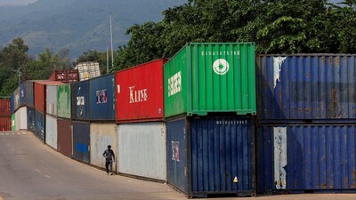 A man walks past shipping containers used to block the area ahead of a planned march by former Pakistani Prime Minister Imran Khan's party, demanding his release and calling for the supremacy of the Constitution and restoration of the rule of law across the country, in Islamabad, Pakistan, September 24, 2026. REUTERS/Akhtar Soomro