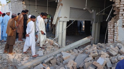 Onlookers gather at the site of an explosion inside the police headquarters at Kohat in Pakistan's Khyber Pakhtunkhwa province on September 18, 2026. (Photo by Basit SHAH / AFP) 