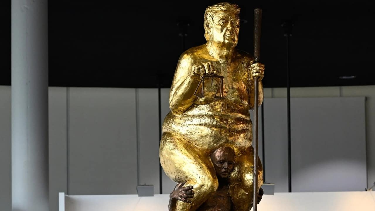Naked, gold-plated and sitting on a smaller man: Why this Trump statue has appeared inside the European parliament