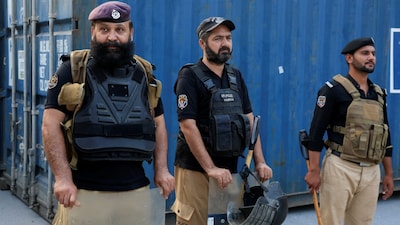 Police officers stand guard near shipping containers used to block access to an area leading to the Red Zone after Pakistan imposed a state of emergency in Khyber Pakhtunkhwa province, effectively suspending the provincial government run by jailed former Prime Minister Imran Khan's party, in Peshawar, Pakistan, October 11, 2026. REUTERS