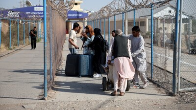 (FILES) Afghan nationals carrying their belongings walk after crossing the border from Iran at the Islam Qala border crossing in Herat province, Afghanistan, September 3, 2026. REUTERS/Sayed Hassib
